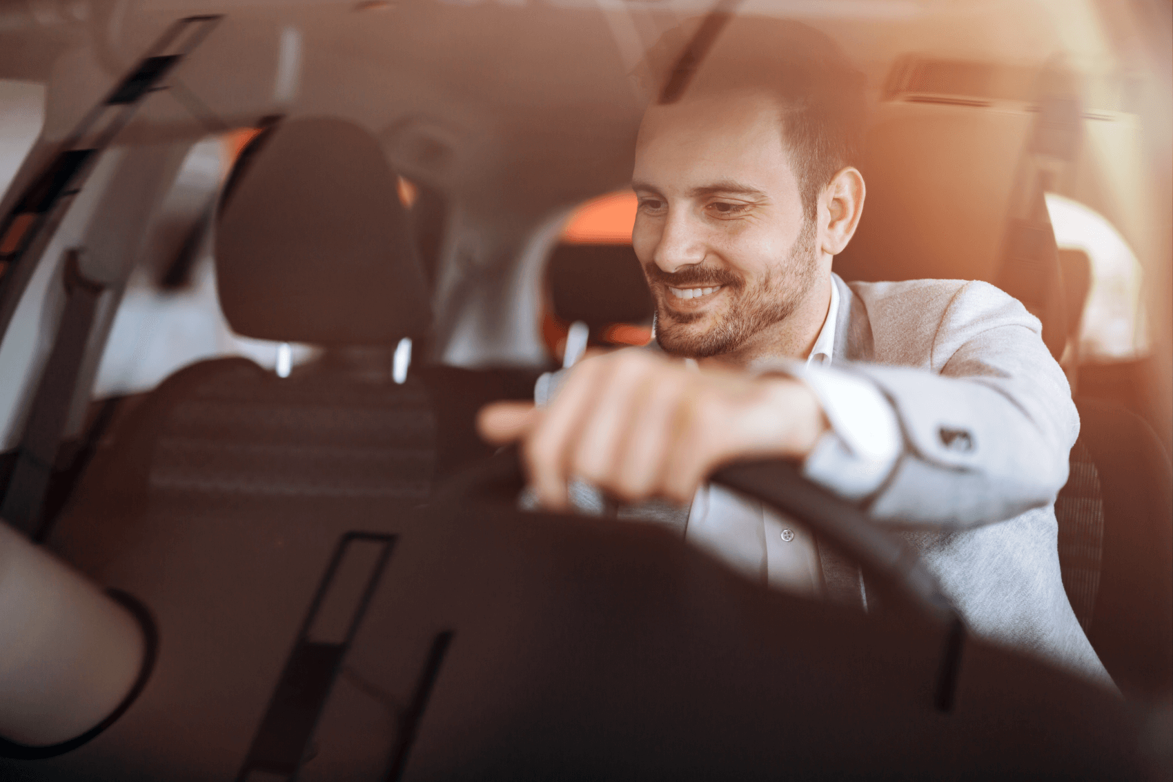Smiling man behind the wheel of a car